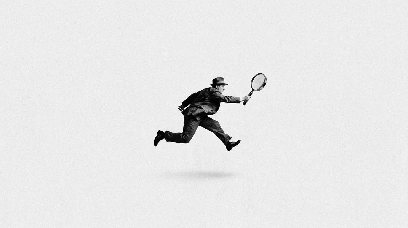 A man in a suit leaping forward with a magnifying glass