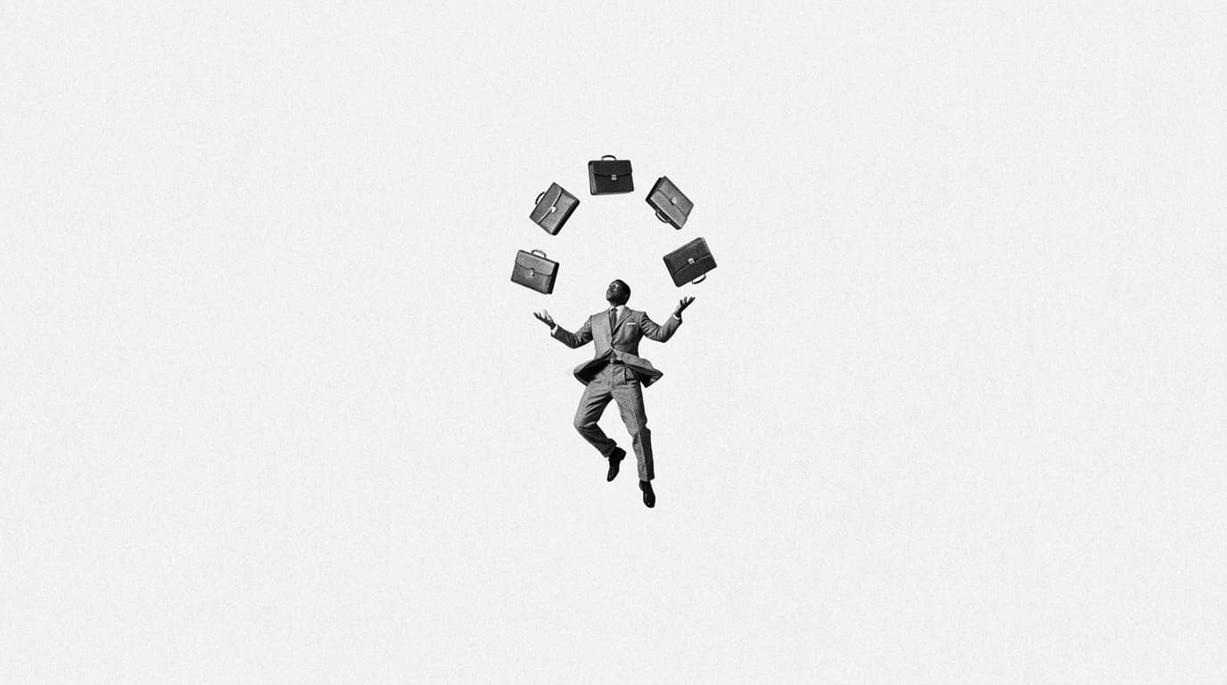 A man in a suit in mid-air juggling five briefcases