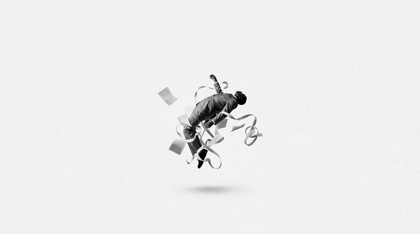 A man in a suit falling backwards, tangled in paper and tape
